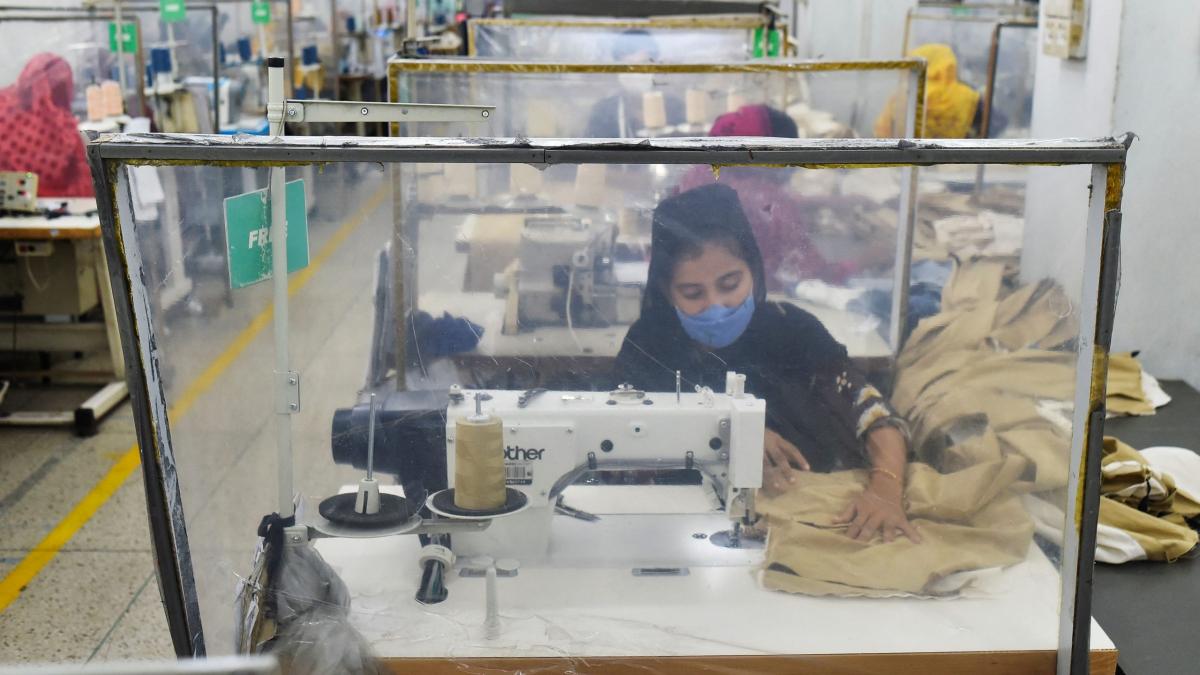 Labourers work at their stations separated by partitions as a preventive measure against the Covid-19 coronavirus at the Civil Engineers Limited garments factory in Dhaka on August 17, 2021. - (Photo by Munir UZ ZAMAN / AFP) (Photo by MUNIR UZ ZAMAN/AFP via Getty Images)