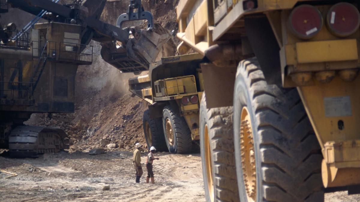 Critical minerals such as copper being mined at a copper mine in Zambia with workers and quarry trucks in action.