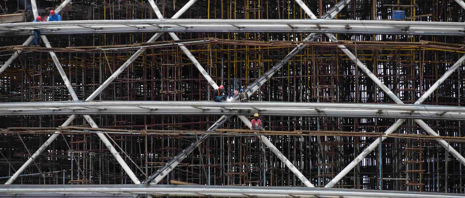 An image of construction workers working together on a large building site in Rwanda