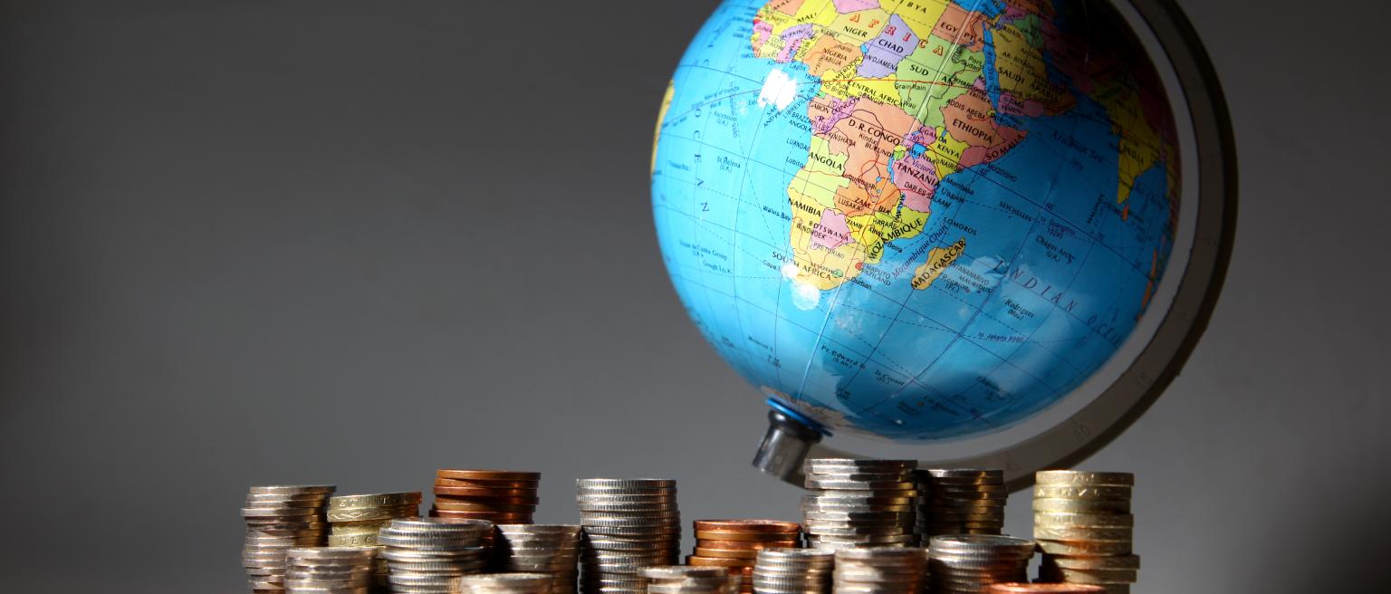 Stacks of money with a globe. Photo credit: Matt Jeacock / iStock / Getty Images Plus via Getty Images.