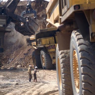 Critical minerals such as copper being mined at a copper mine in Zambia with workers and quarry trucks in action.
