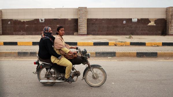 Two women riding a motor bike in Pakistan.