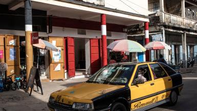 A taxi drives in front of old colonial buildings in central Giuinchor (Photo by JOHN WESSELS - AFP via Getty Images)