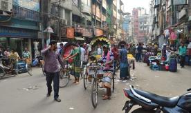 busy street in Dhaka. people riding tuk-tuks. Photo taken by Francisco Anzola