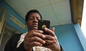 Woman reads message on her iPhone in Kampala