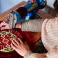 A woman sewing a pillow cover with a machine in Pakistan.