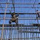 Labourers work at a construction site of a road bridge in Lahore