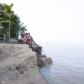 People standing at the edge of a river bank that has eroded due to climate change, in Bangladesh