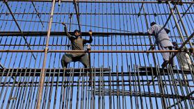 Labourers work at a construction site of a road bridge in Lahore