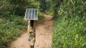 Woman carrying a solar pannel near Yangambi, DRC - Photo by Axel Fassio - CIFOR via Flickr