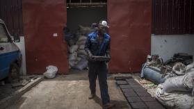 Workers process recycled plastic into blocks which can be used in road construction