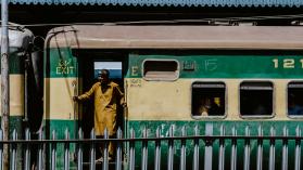 Man wearing brown clothes standing in the door of a train