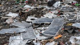 Electronic wastes including solar panels lying on the ground.