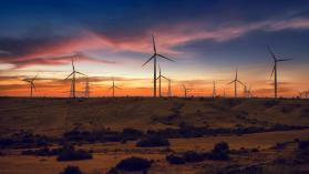 A landscape of a wind farm at sunset demonstrates the urgent need renewable energy in Pakistan to overcome the electricity crisis.