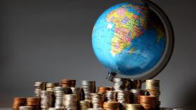 A globe surrounded by piles of coins to demonstrate the challenges of financing for development.