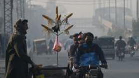 A man sells corn in smoggy Lahore