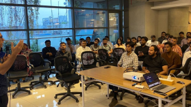 A presenter speaking to a room full of people as part of a startup accelerator programme in Dhaka, Bangladesh.