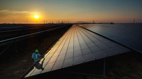 An image of a solar panel installation in India against a setting sun.
