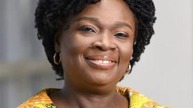 Victoria Kwakwa smiling at camera, wearing yellow.