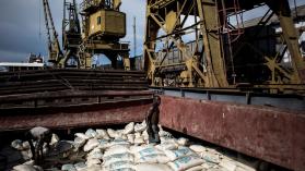 A person unpacking bags of cement in a cargo boat in Tanzania illustrating the theme of firms, trade and development.