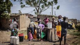 A group of residents gathering near an informal settlement in Zambia.