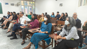 A photo of an audience watching a presentation in attendance at a conference held in India.