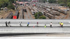 Workers sweep away loose chippings at the newly constructed Nairobi expressway along Mombasa road in Nairobi on March 23, 2022. Photo credits: Simon Maina / AFP via Getty Images.