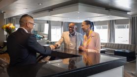 Couple receiving their room key at hotel reception. 