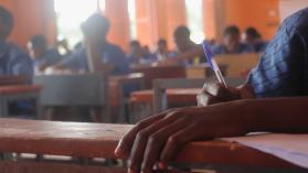 An intimate perspective on the crucial Basic Education Certificate Examination (BECE) in Ghana, featuring a close-up of a student's hand poised with a pen, actively engaged in writing. Photo credits: Willian Borney / iStock / Getty Images Plus via Getty Images.