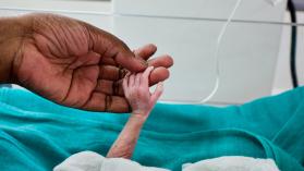 Doctor holding newborn babys hand in Neonatal Unit of hospital. Photo credit: Pal Teravagimov Photography / Moment Open via Getty Images.