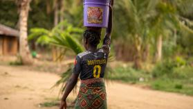 Palma, Mozambique: A young African girl balances a container of water on her head in Cabo Delgado.
