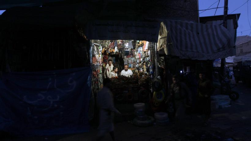 A Yemeni vendor uses a lantern to light his shop at a market in the capital Sanaa in 2015. Photo by Mohammed Huwais/AFP via Getty Images.