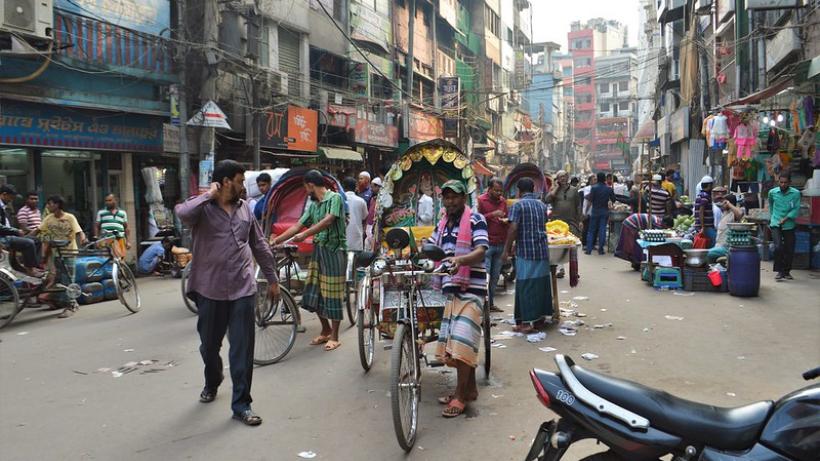 busy street in Dhaka. people riding tuk-tuks. Photo taken by Francisco Anzola