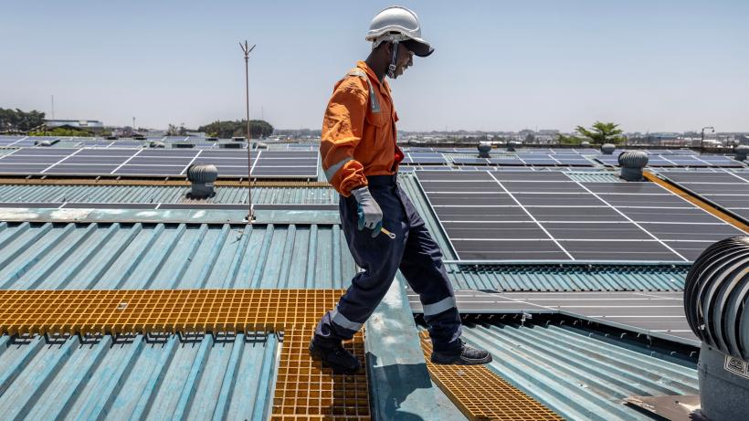 Technician walking on solar roof in Kenya