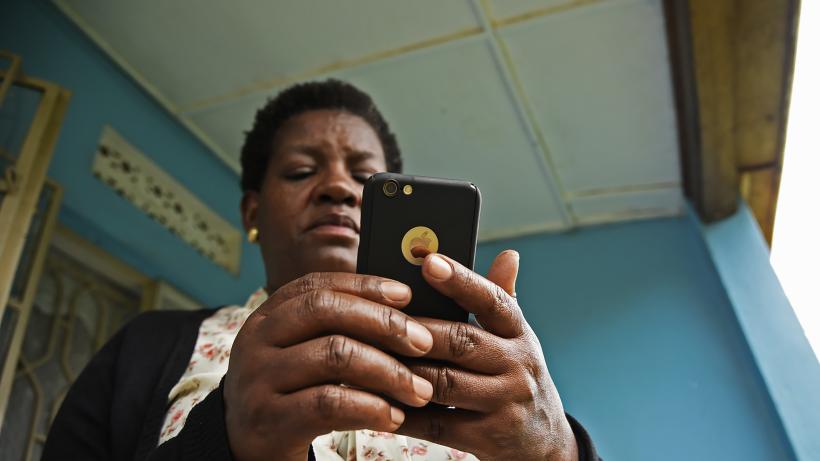 Woman reads message on her iPhone in Kampala