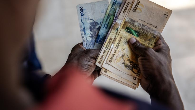 A man working for a forex bureau displays some Ugandan shilling notes