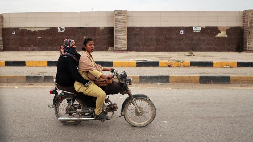 Two women riding a motor bike in Pakistan.