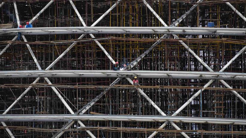 An image of construction workers working together on a large building site in Rwanda