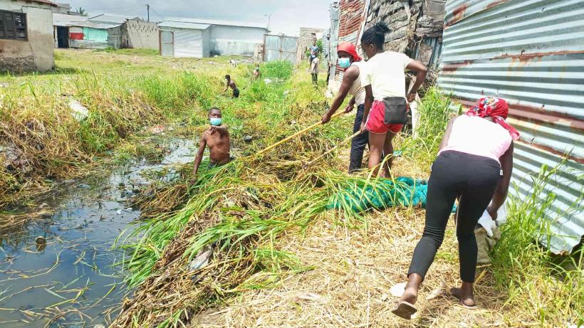 Group of people clearing a drainage canal.
