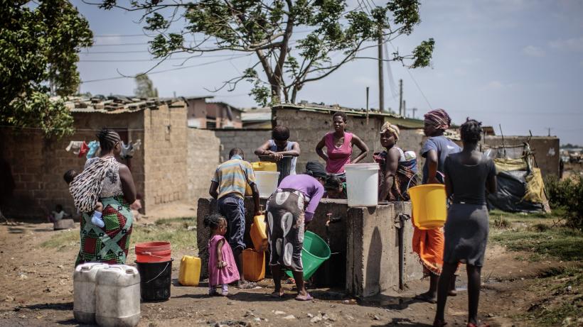A group of residents gathering near an informal settlement in Zambia.