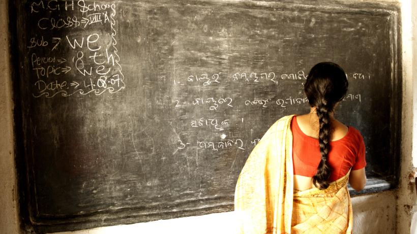 School teacher writing on a blackboard in Ngo Patang, Sambalpur, Orissa, India.