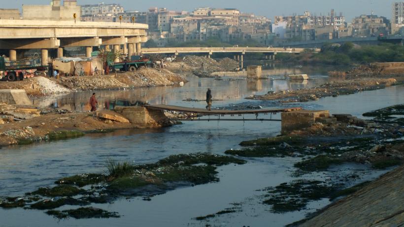 People are using makeshift bridge for crossing over the water flow in the riverbed of Lyari River, Karachi.  The temporary bridge allow people living both sides of the river to reach over from one to another place. Photo credit: Bashir Osman's Photography / Moment via Getty Images.