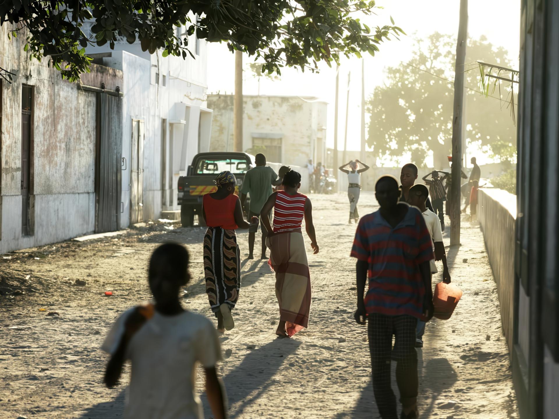 People walking on a path in Mozambique with the sun setting. 