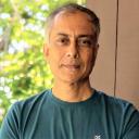 A headshot of E Somanathan wearing a green T-shirt.