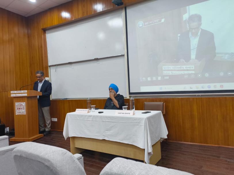 An image of an academic presenting a paper at a conference in India.