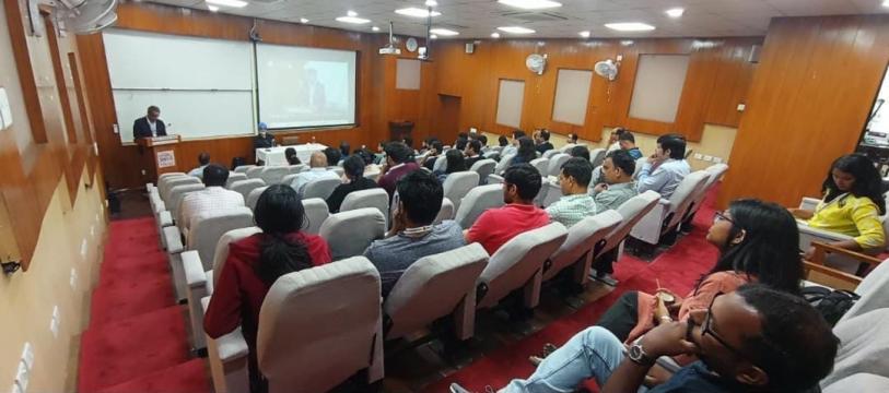 A photo of an audience listening to a presentation being delivered at a conference in India.